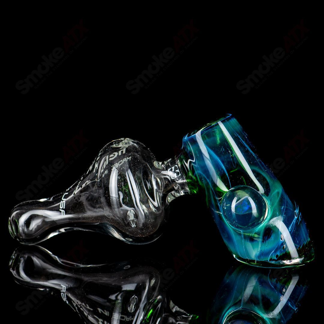 American Helix White Label Hammer glass pipe with blue-green box fan helix design, showcasing intricate glasswork and vibrant colors.