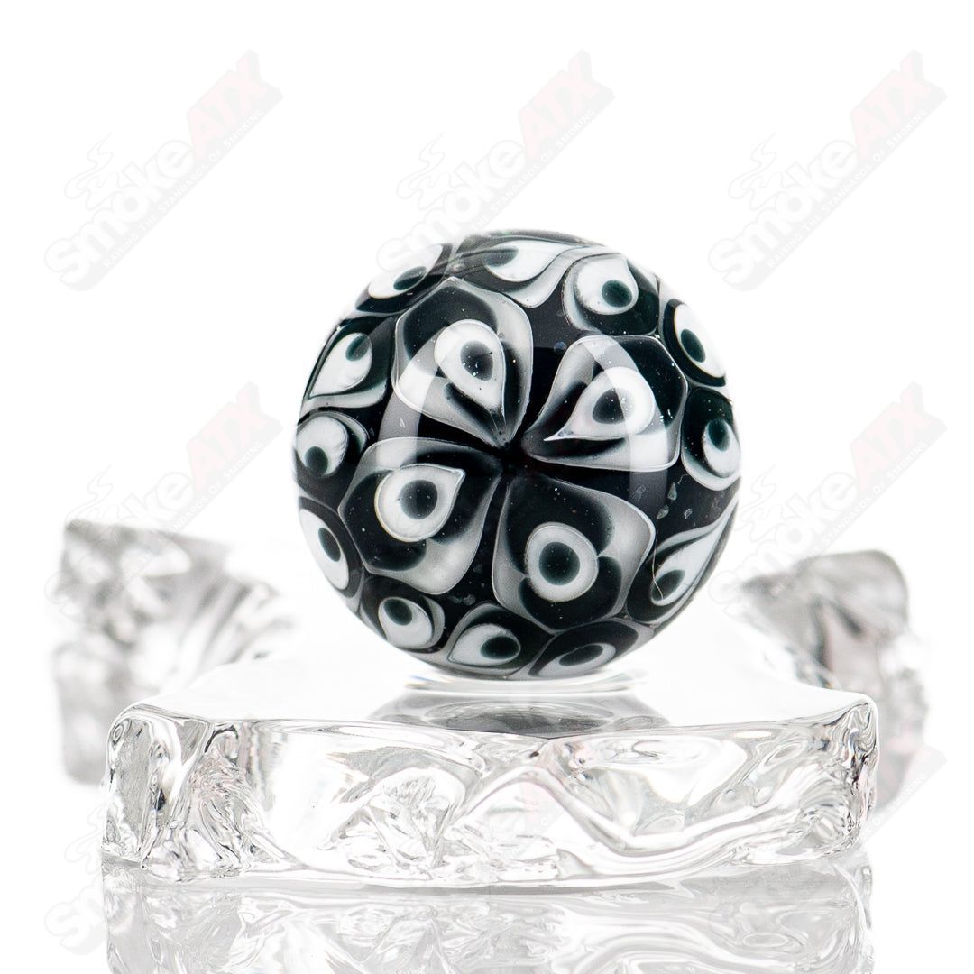 Black Magic UV Pinwheel Top glass marble by Indo Glass, featuring vibrant swirl patterns and a glossy finish.